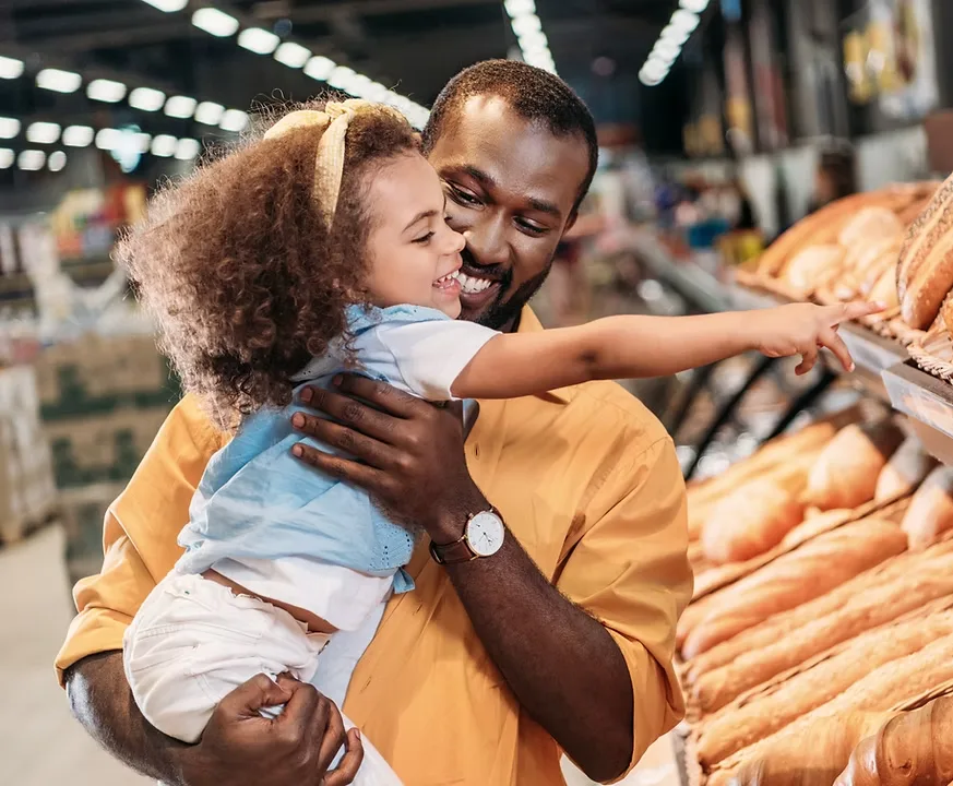 Father and daughter shopping for bread in a grocery store